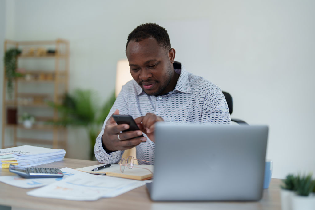 Man thuis op telefoon aan het werk 