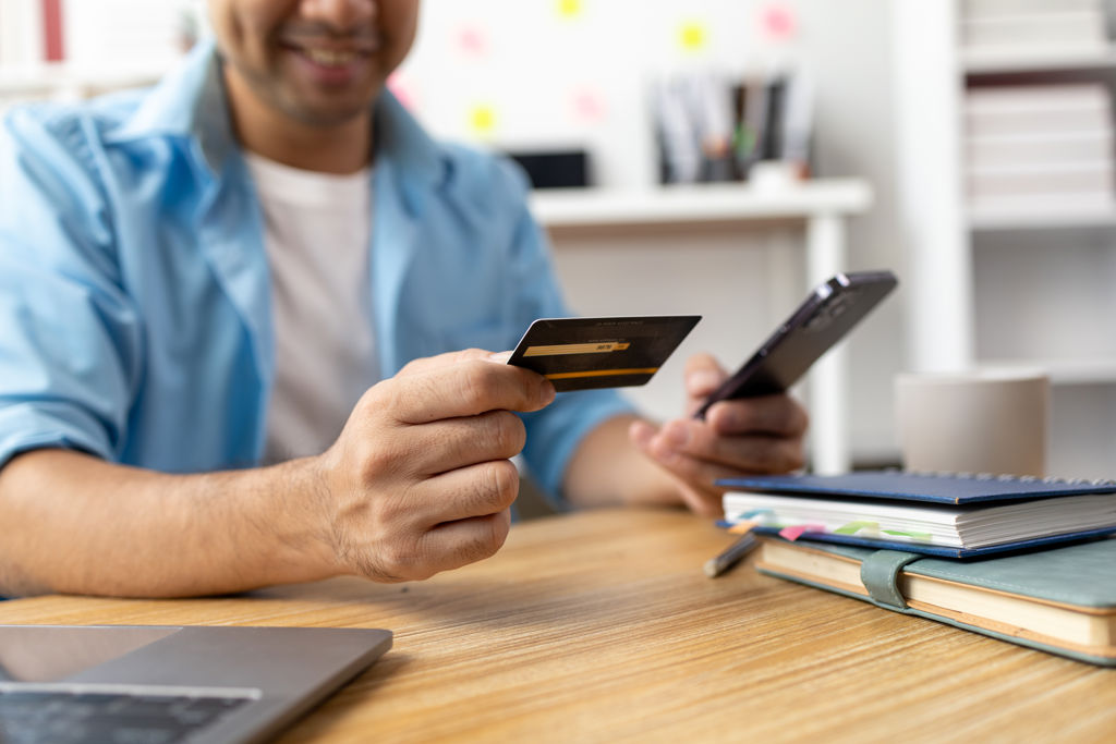 man met telefoon en creditcard in hand