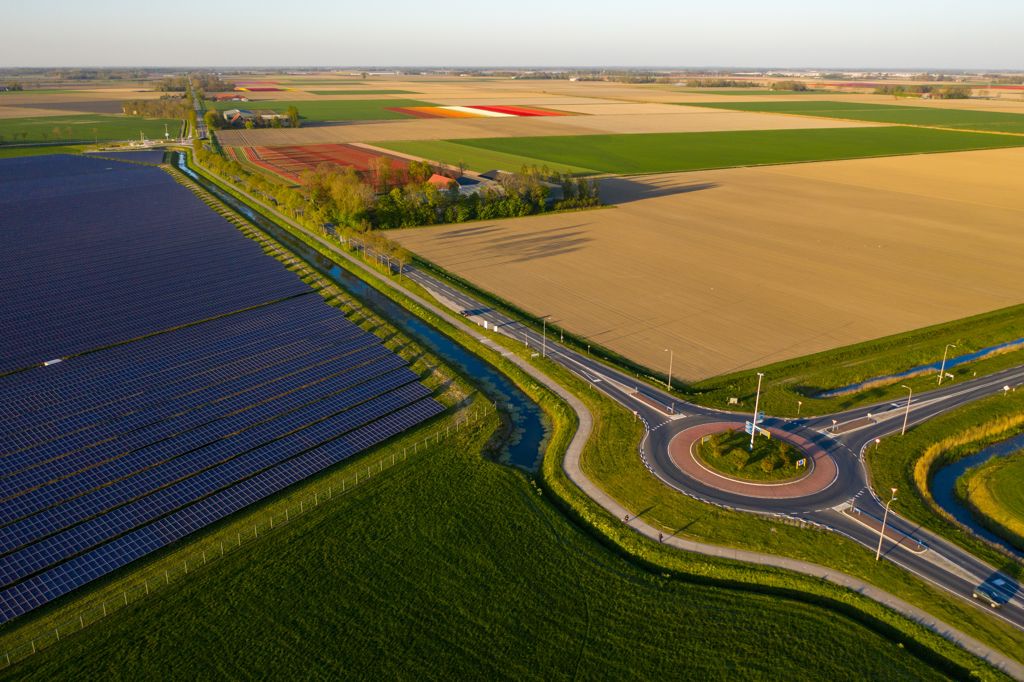 Blik vanuit de lucht op een stuk land met zonnepanelen