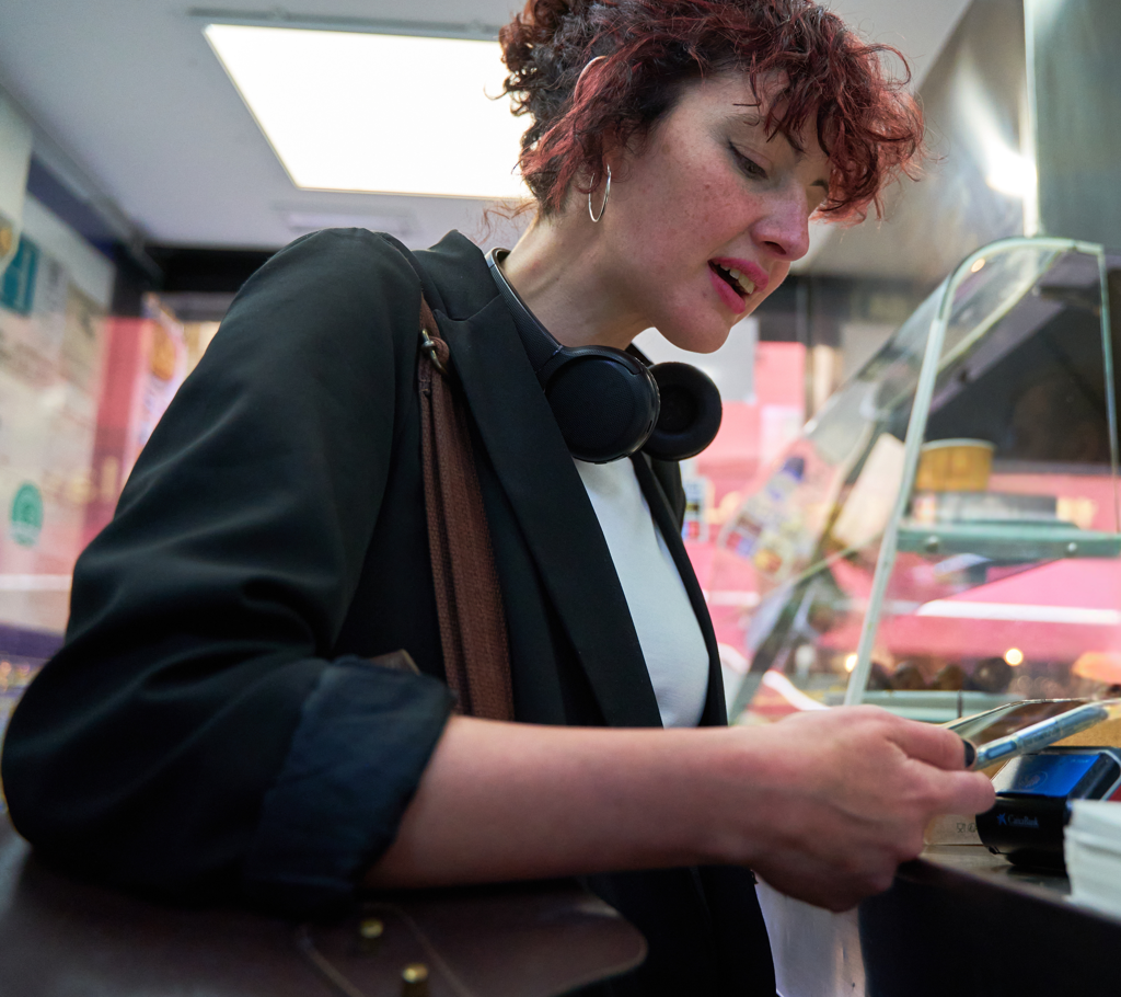 vrouw betaalt in snackbar met telefoon