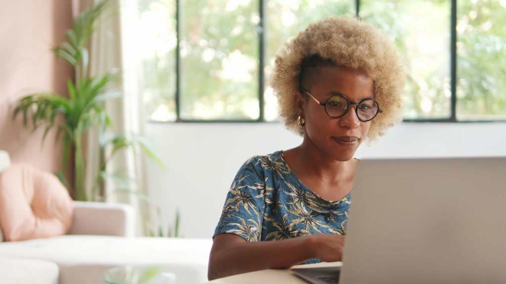 Vrouw thuis achter haar laptop
