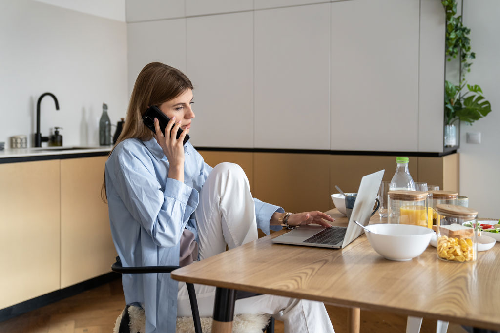 Vrouw aan het bellen aan keukentafel