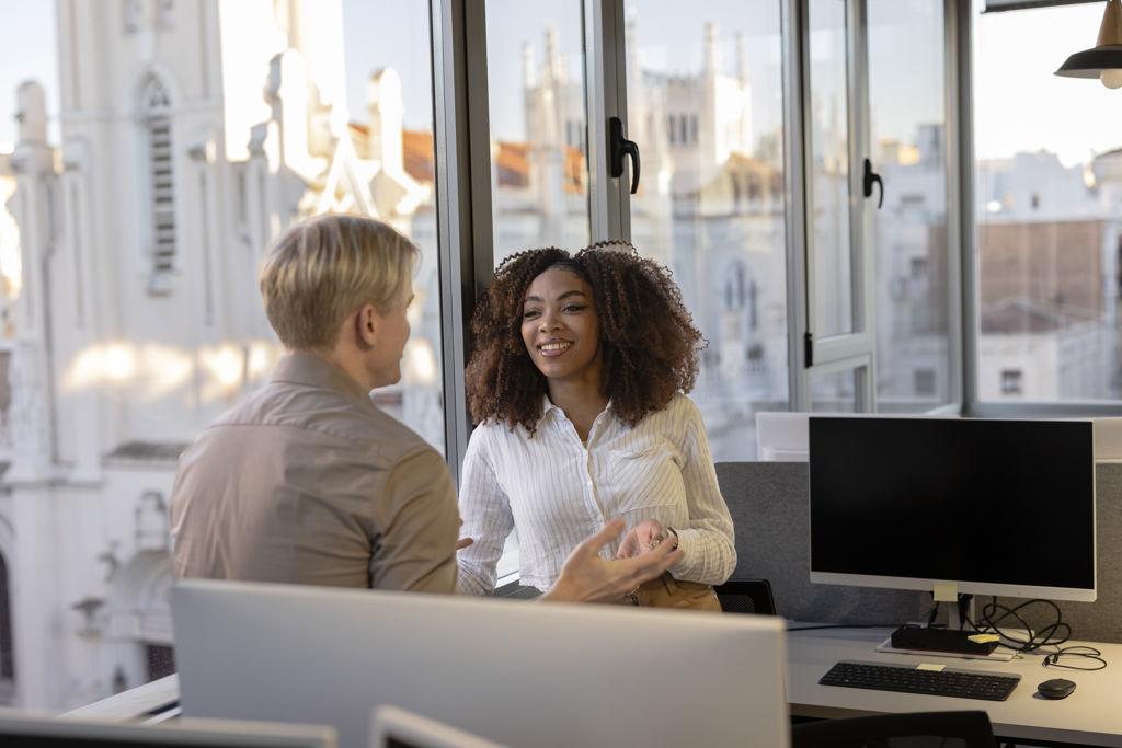 Twee collega's in gesprek op kantoor