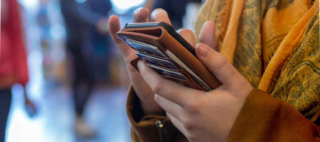 vrouw kijkt op telefoon in hand