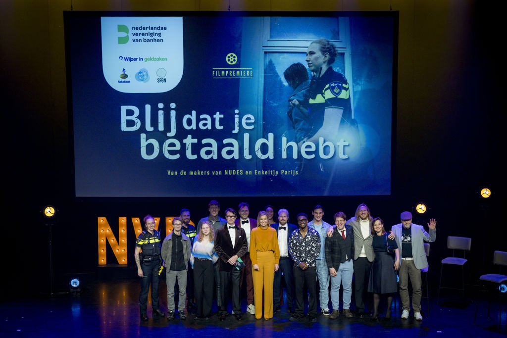 Makers, partners en genodigden poseren bij de première van Blij dat je betaald hebt.